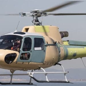 Helicopter cockpit instrument panel with various gauges and screens.