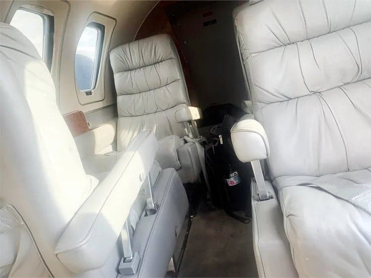 Interior view of the Cessna CitationJet cabin with white leather seats.