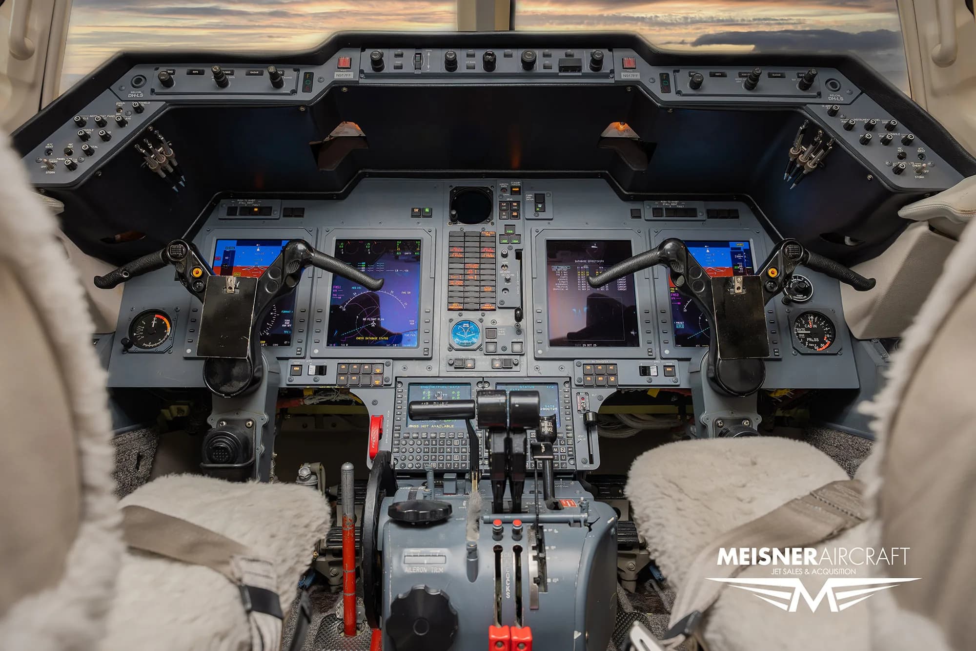 The cockpit of a business jet with multiple screens and controls.