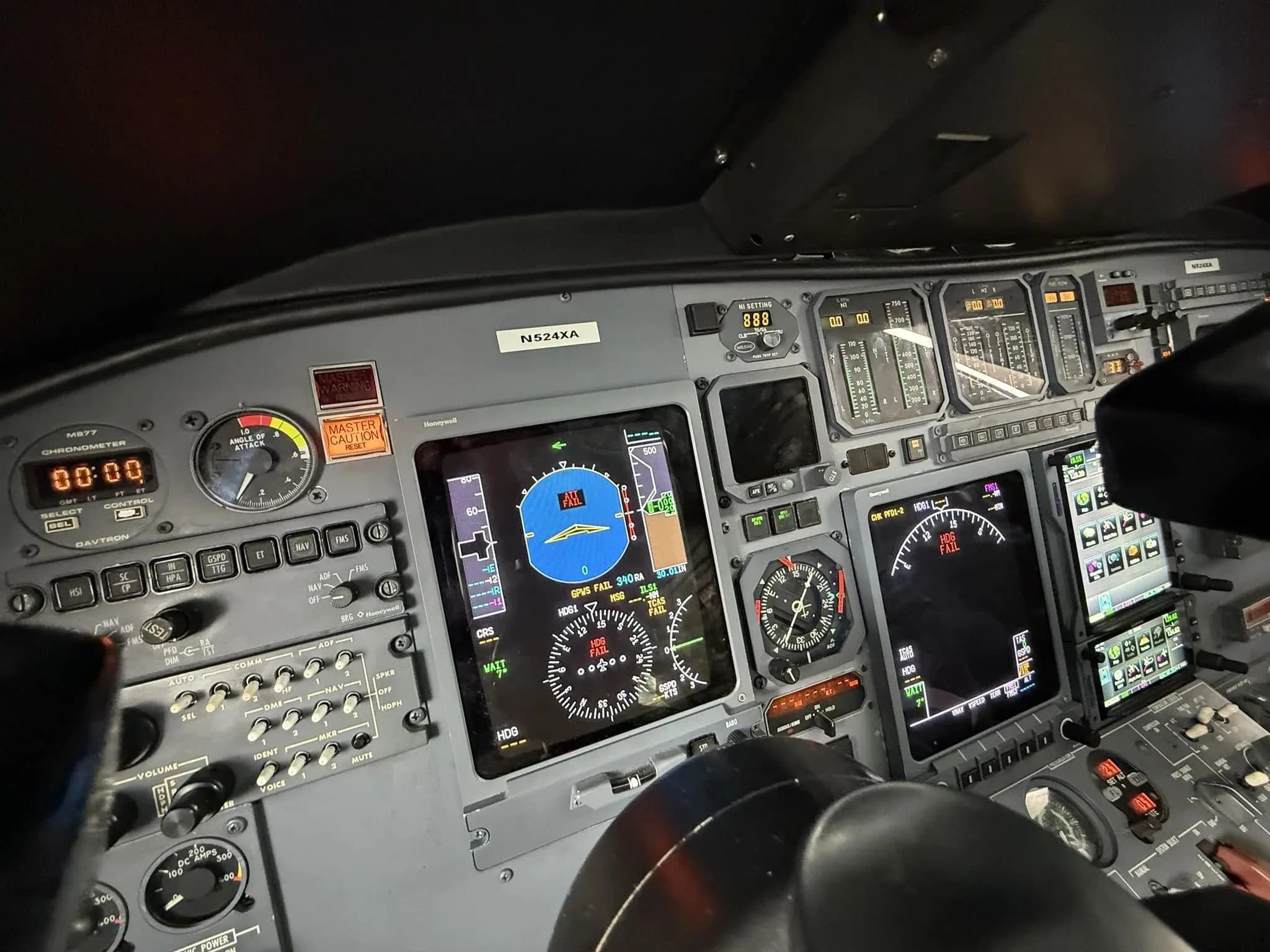 A close-up view of the cockpit instrument panel of the N524XA business jet, showing multiple displays and controls.