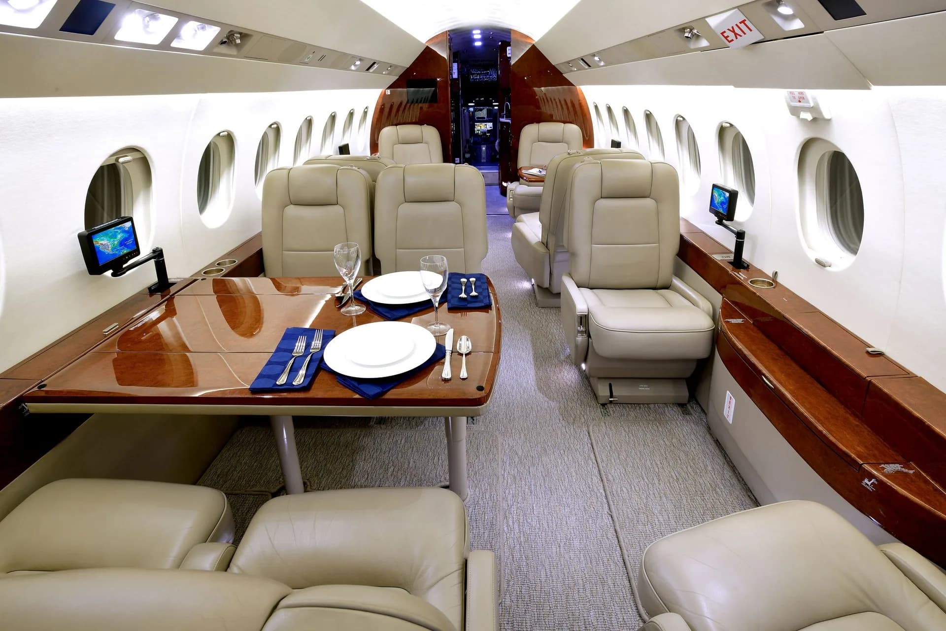 View of the aircraft's interior cabin with leather seats and a dining table set for a meal.
