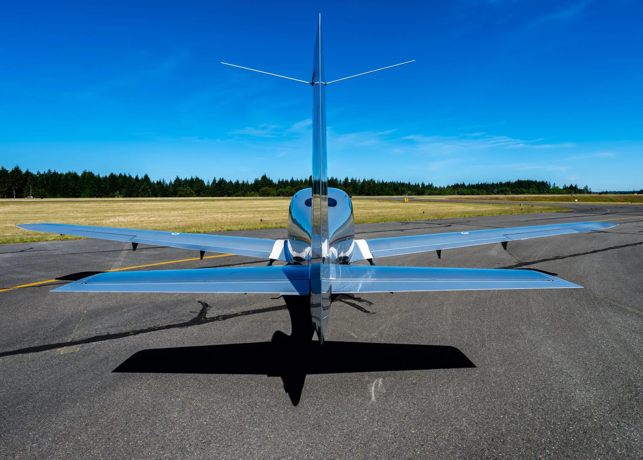 Rear view of a silver Cirrus SR22T aircraft with registration N95CM parked on an airfield.