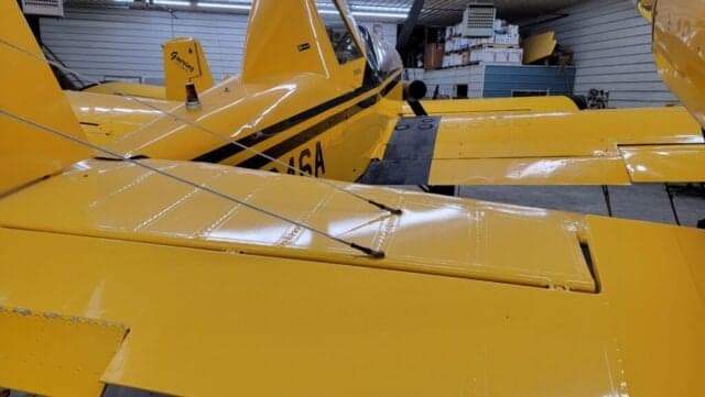 Yellow and black aircraft with the registration number N9646A parked in a hangar.