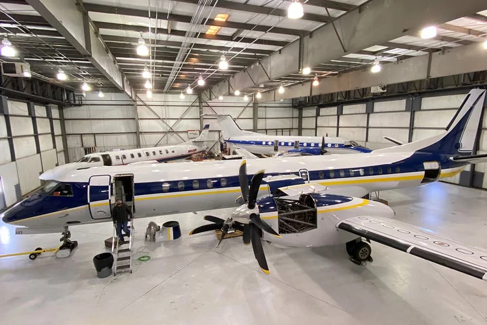 Aircraft in a hangar with its door open.