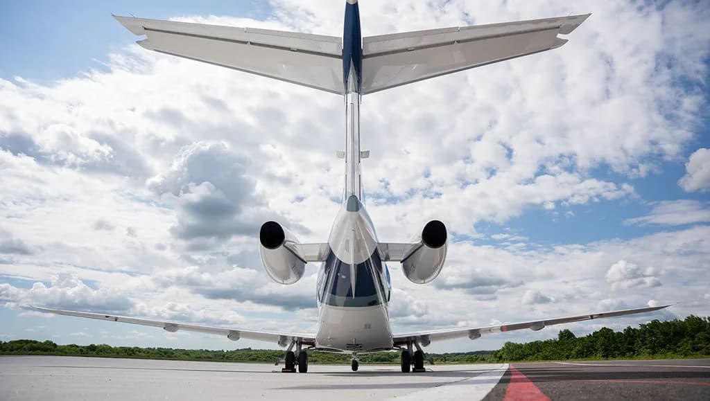 A rear view of the Pilatus PC-24 business jet, registration N74JX, parked on an airfield.