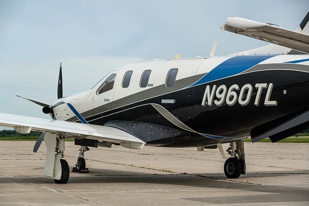 A side view of the TBM 960 turboprop aircraft, registration N960TL, parked on an airfield.