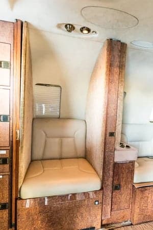 A view of the interior cabin of the aircraft, showing the seating arrangement and wood paneling.