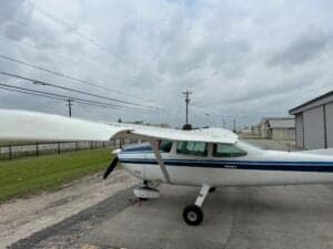 A Cessna aircraft parked on the tarmac with a white and blue paint scheme.