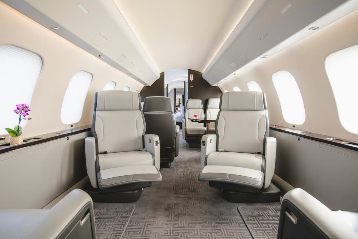 View of the aircraft interior with white leather seats and a table.