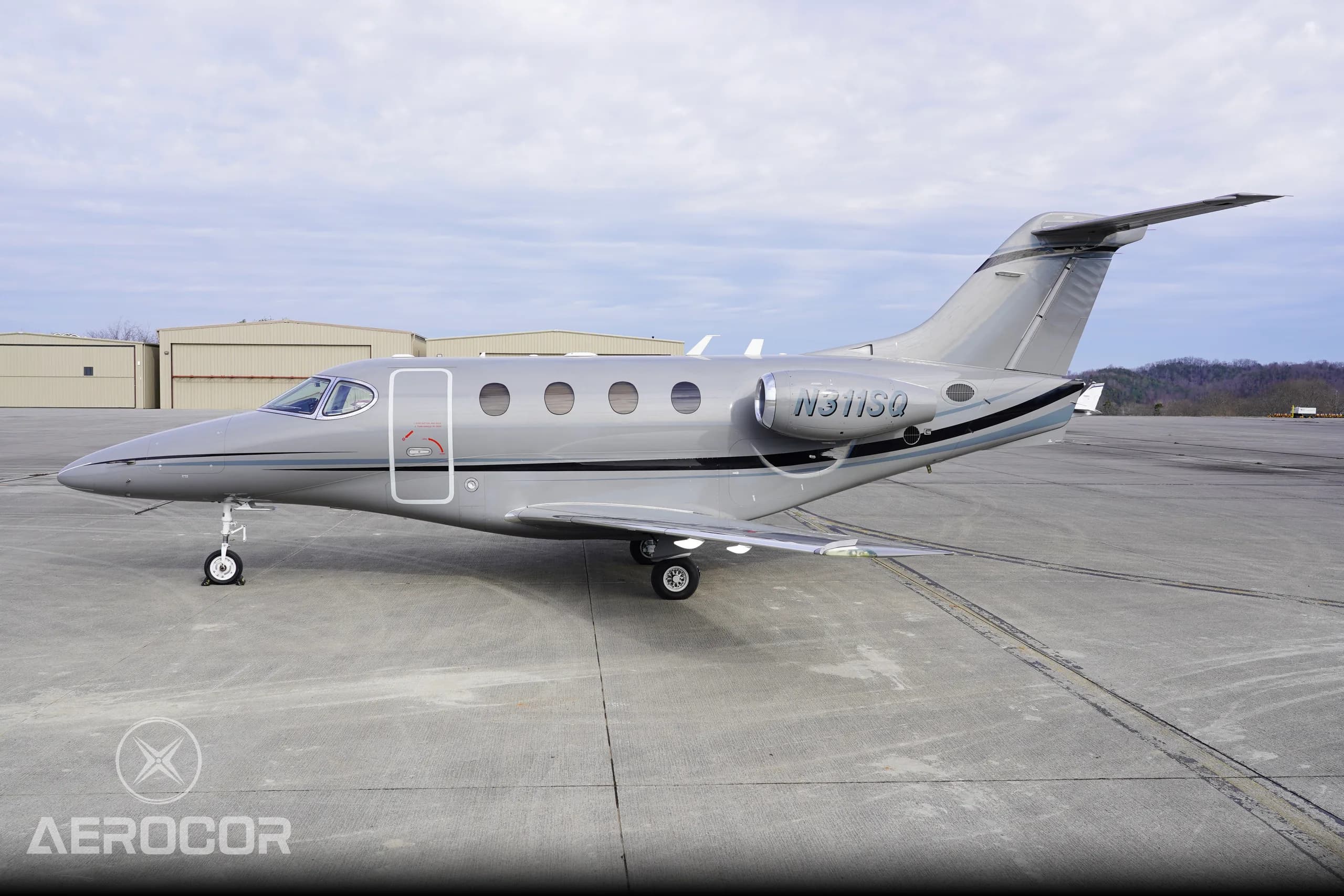 A side view of the gray Raytheon Premier I business jet, registration N311SQ, parked on a concrete ramp.
