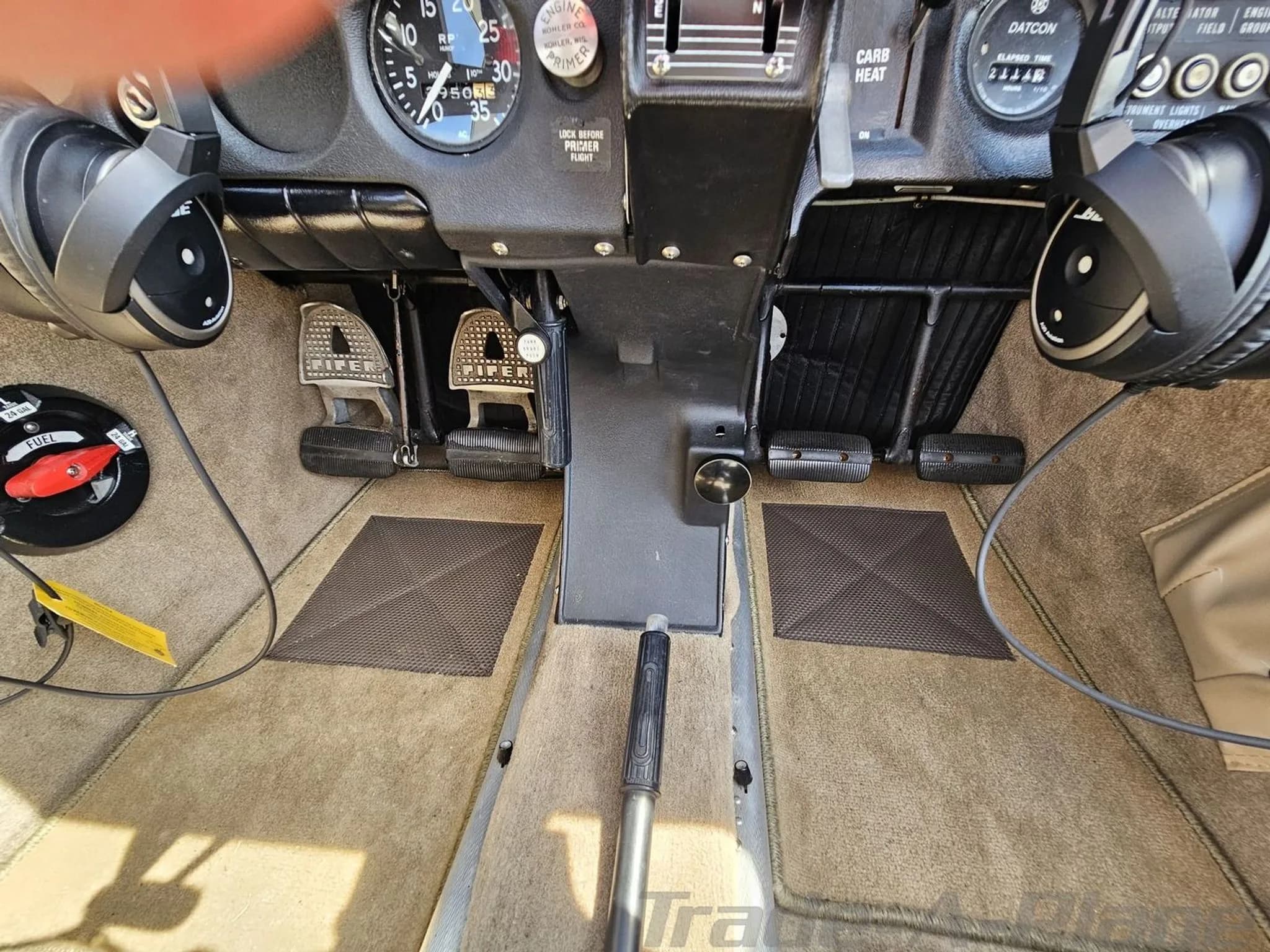 View of the rudder pedals and floor area in the cockpit of a Piper PA-28 aircraft.