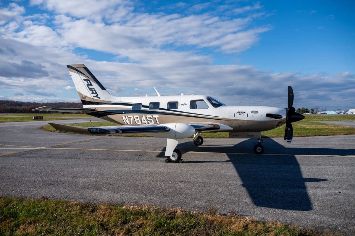 Side view of the Fury M700 aircraft with tail number N784ST on the tarmac.