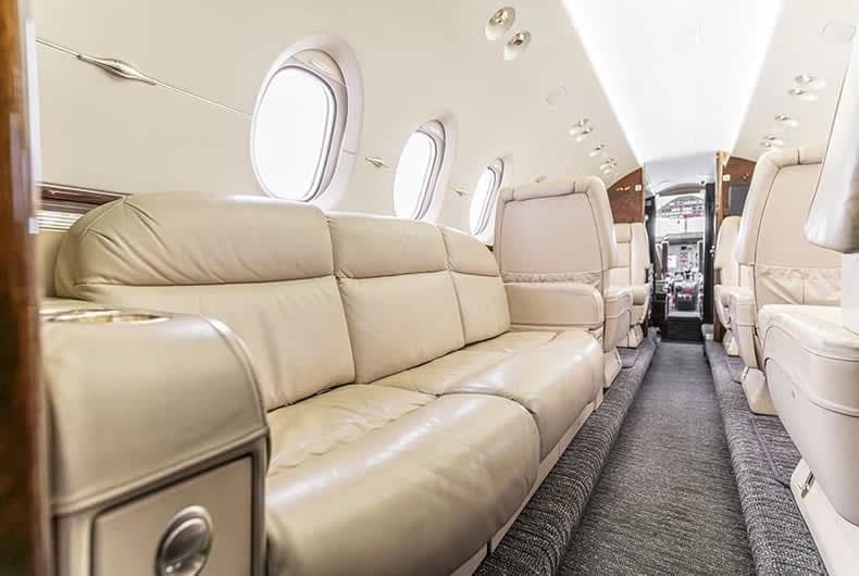 View of the aircraft's interior with a leather couch and seats.