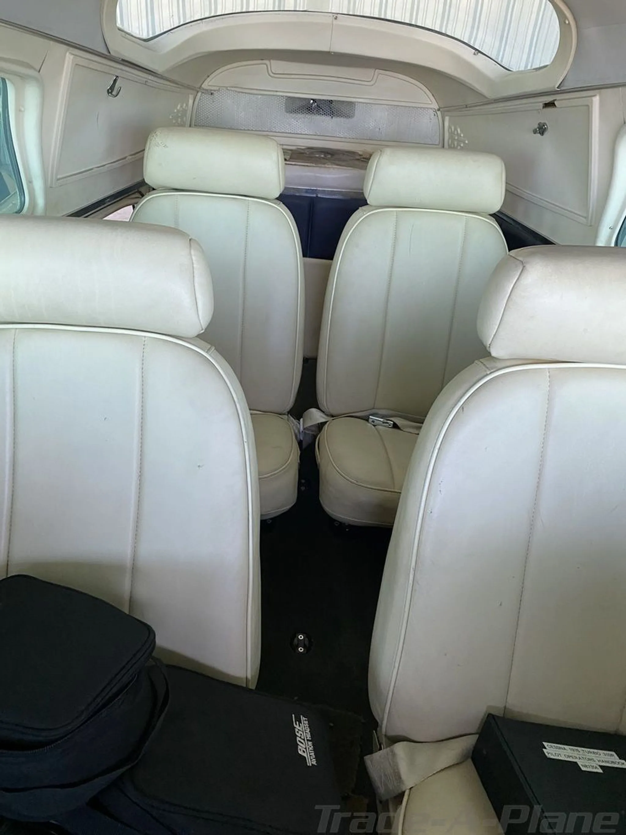 The aircraft's cabin interior with four white leather seats.