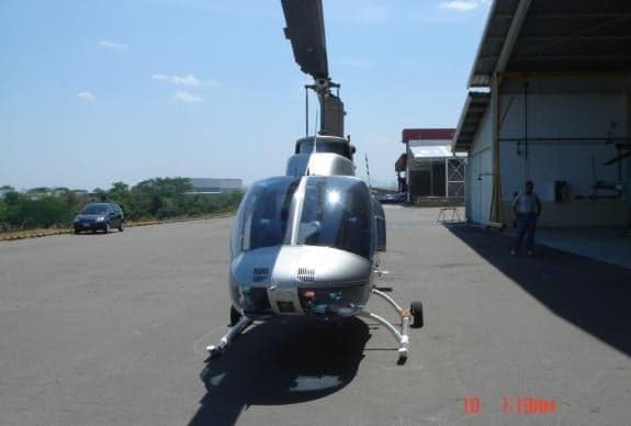Front view of a silver helicopter on the tarmac.