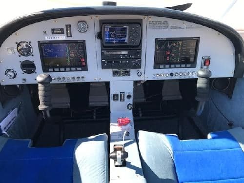 The cockpit of the aircraft features a gray instrument panel and blue seats.