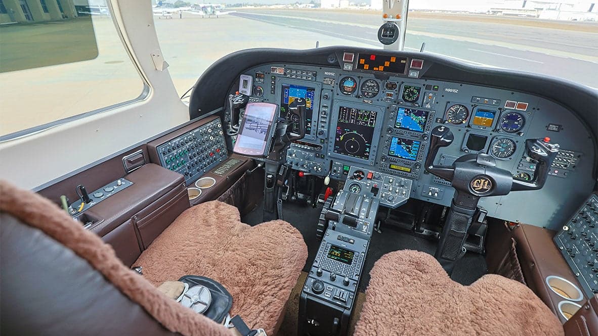 The cockpit of a Cessna Citation CJ1 aircraft, showing the instrument panel and seats.