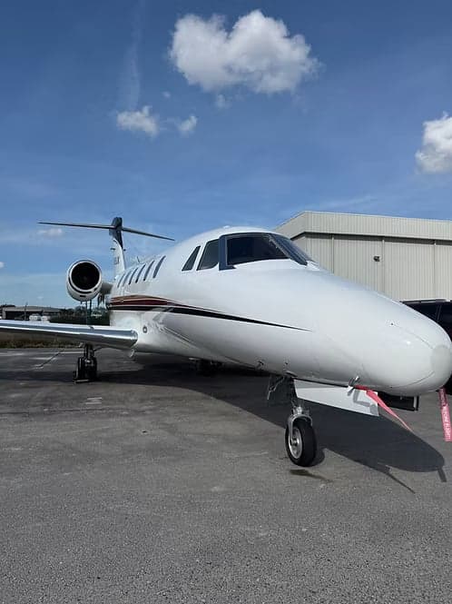 Cessna Citation CJ3+ on the tarmac in front of a hangar.