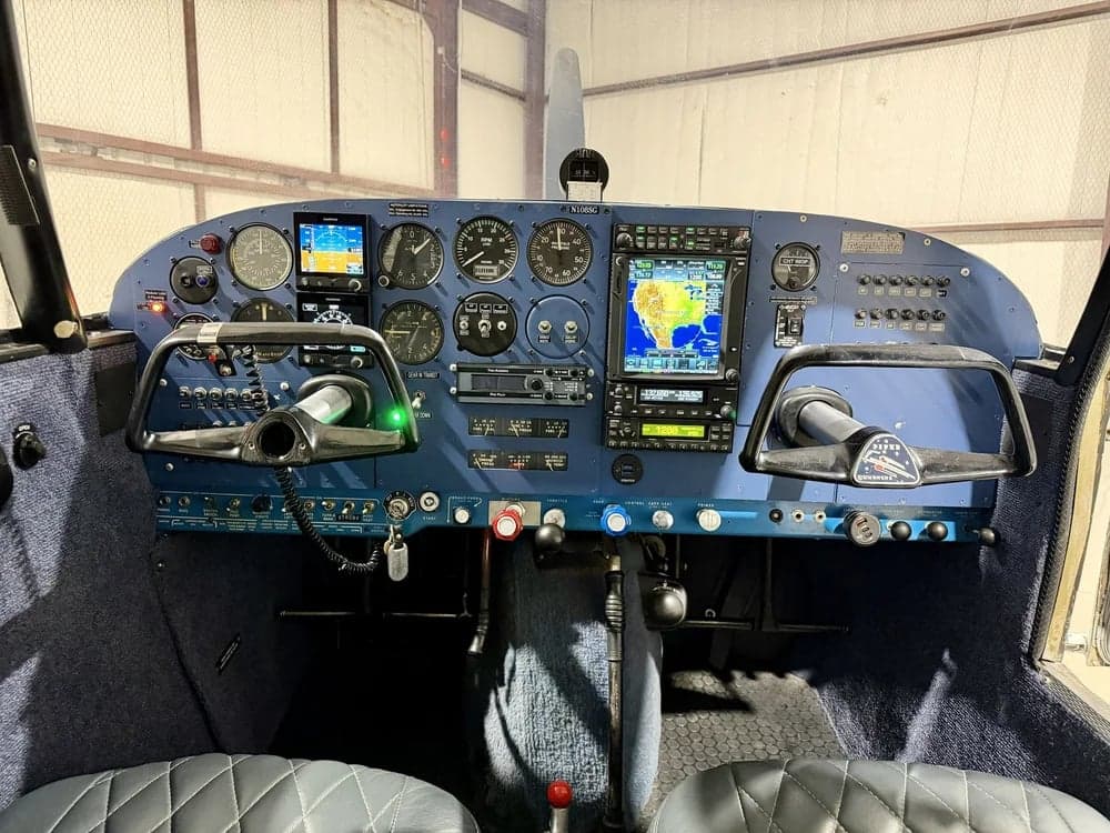 The cockpit of the Piper PA-28-140 Cherokee features a blue instrument panel and yokes.