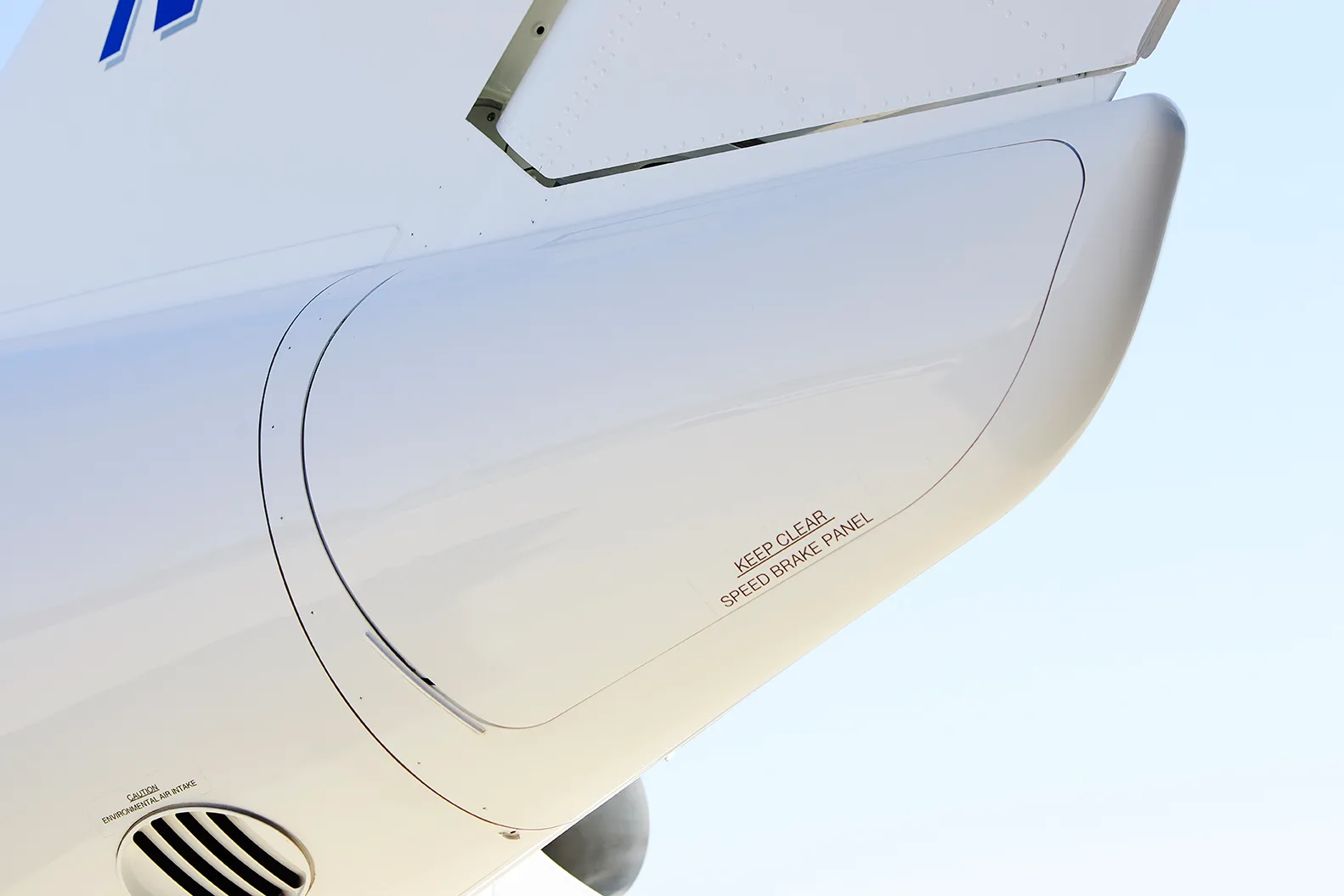 Close-up view of a panel on the fuselage of the HondaJet with "NO STEP" and "SAFETY LATCH" markings.