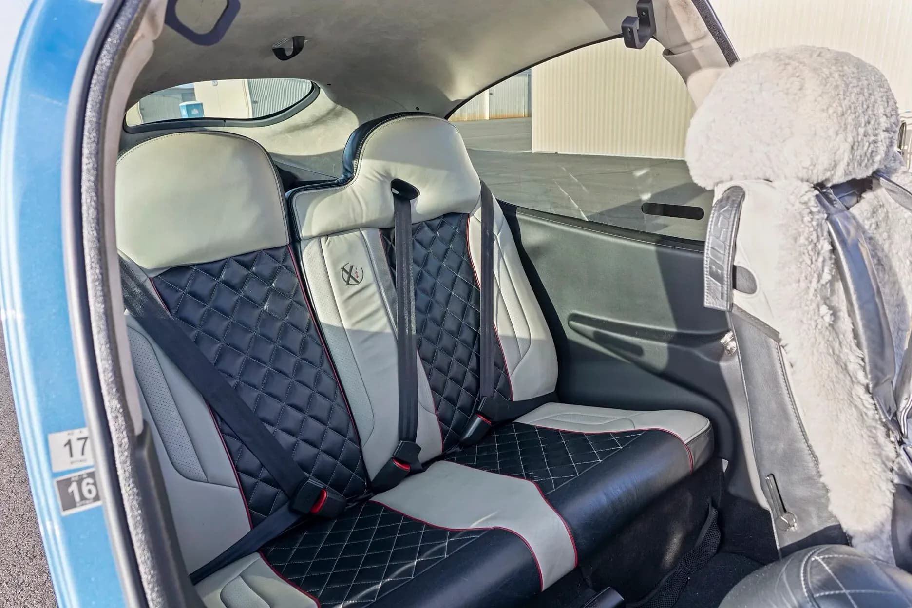 The aircraft's interior showing the black and light grey passenger seats with diamond stitching.