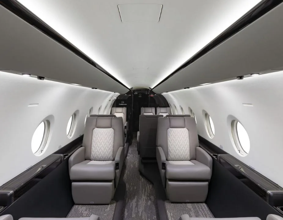 View of the aircraft cabin with leather seats and dark wood accents.