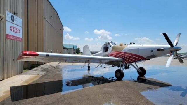 A Thrush 510G aircraft with a white and red paint scheme is parked on the tarmac.