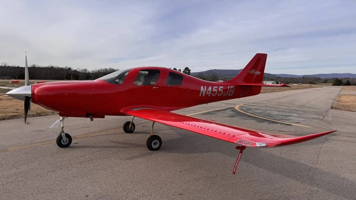 A red Lancair IV-P parked on the tarmac.