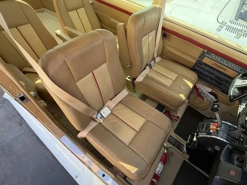 Close-up view of the tan leather front seats and part of the cockpit controls in a Cessna 310 aircraft.
