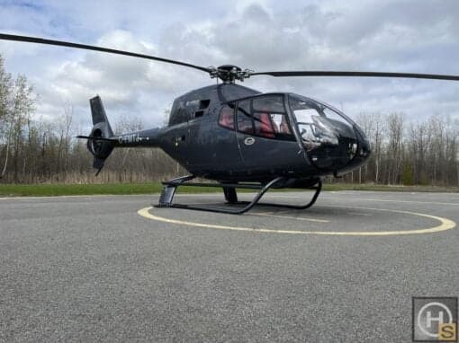 An Airbus helicopter, registration C-FMTJ, is parked on a helipad.