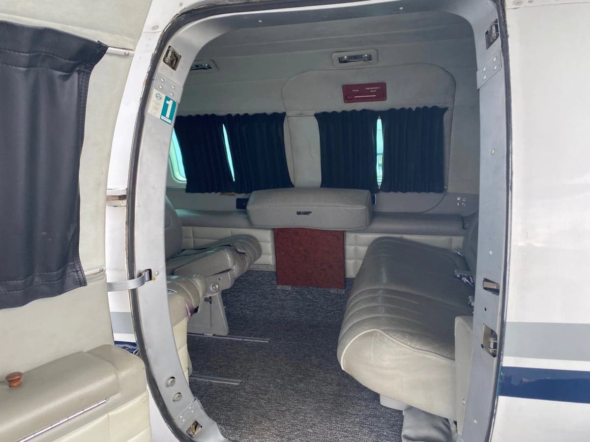 The interior of the aircraft features gray seats and black curtains.