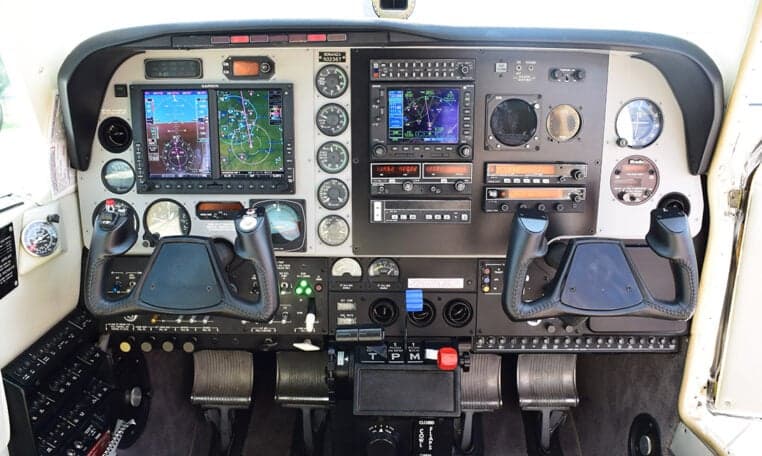 The aircraft's cockpit features a modern instrument panel with multiple display screens, gauges, and control yokes.