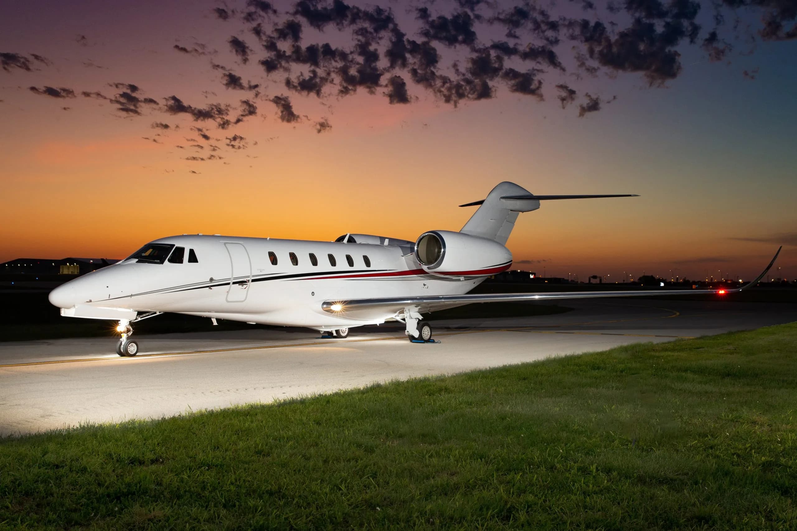 A Citation CJ4 aircraft is parked on the tarmac at dusk.