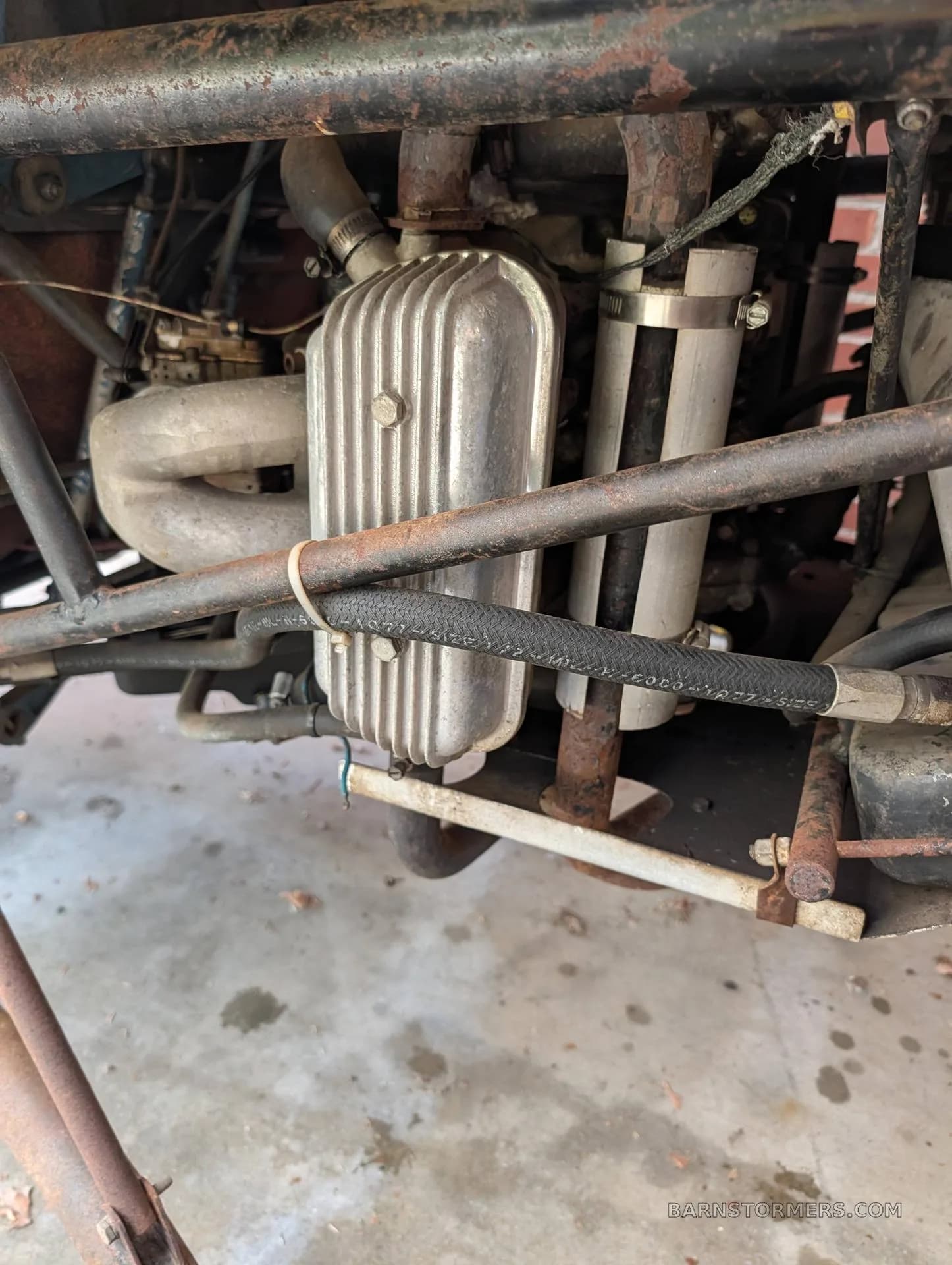 A close-up view of the exposed engine and mechanical components of an experimental helicopter, showing pipes and a silver valve cover.