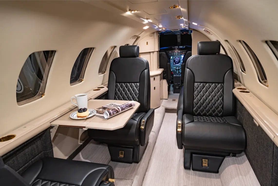 View of the interior cabin of the Cessna Citation Ultra, showing the seating arrangement and table.