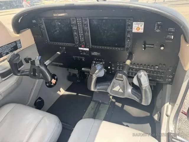 The cockpit of a Piper Archer TX, featuring a modern glass panel with two large displays and dual yokes.