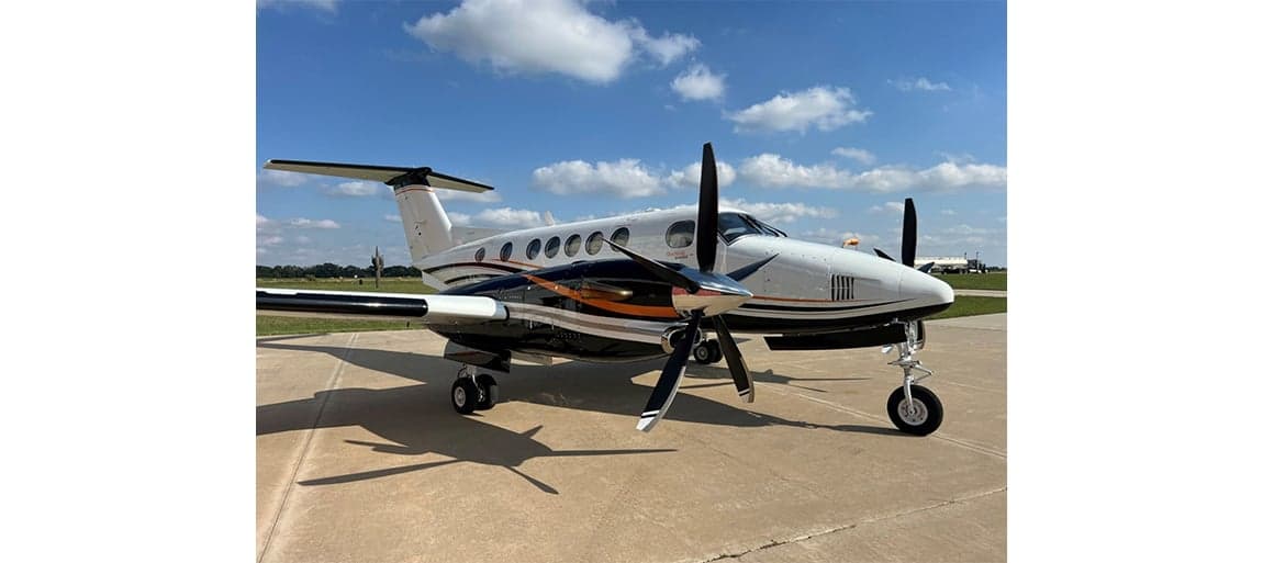 King Air aircraft parked on the tarmac with a black and white paint scheme.