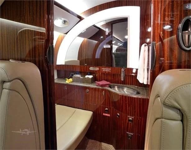 A view of the aircraft's lavatory, featuring wood paneling and a sink.