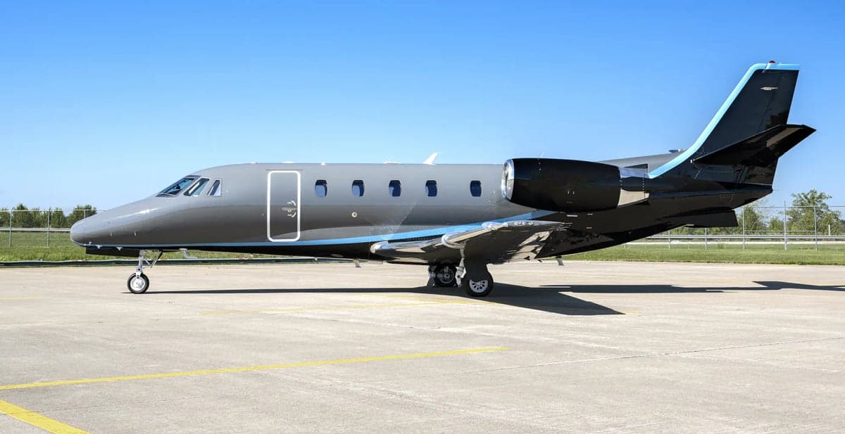 A Cessna Citation business jet on the tarmac with a gray and black paint scheme.
