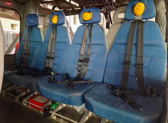 Close-up of the helicopter's blue passenger seats with headsets.