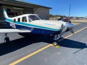 Piper Saratoga II HP aircraft with blue and white paint scheme parked on the tarmac.