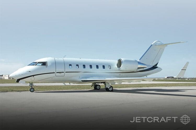 Side view of a white Bombardier Challenger 300 on the tarmac.
