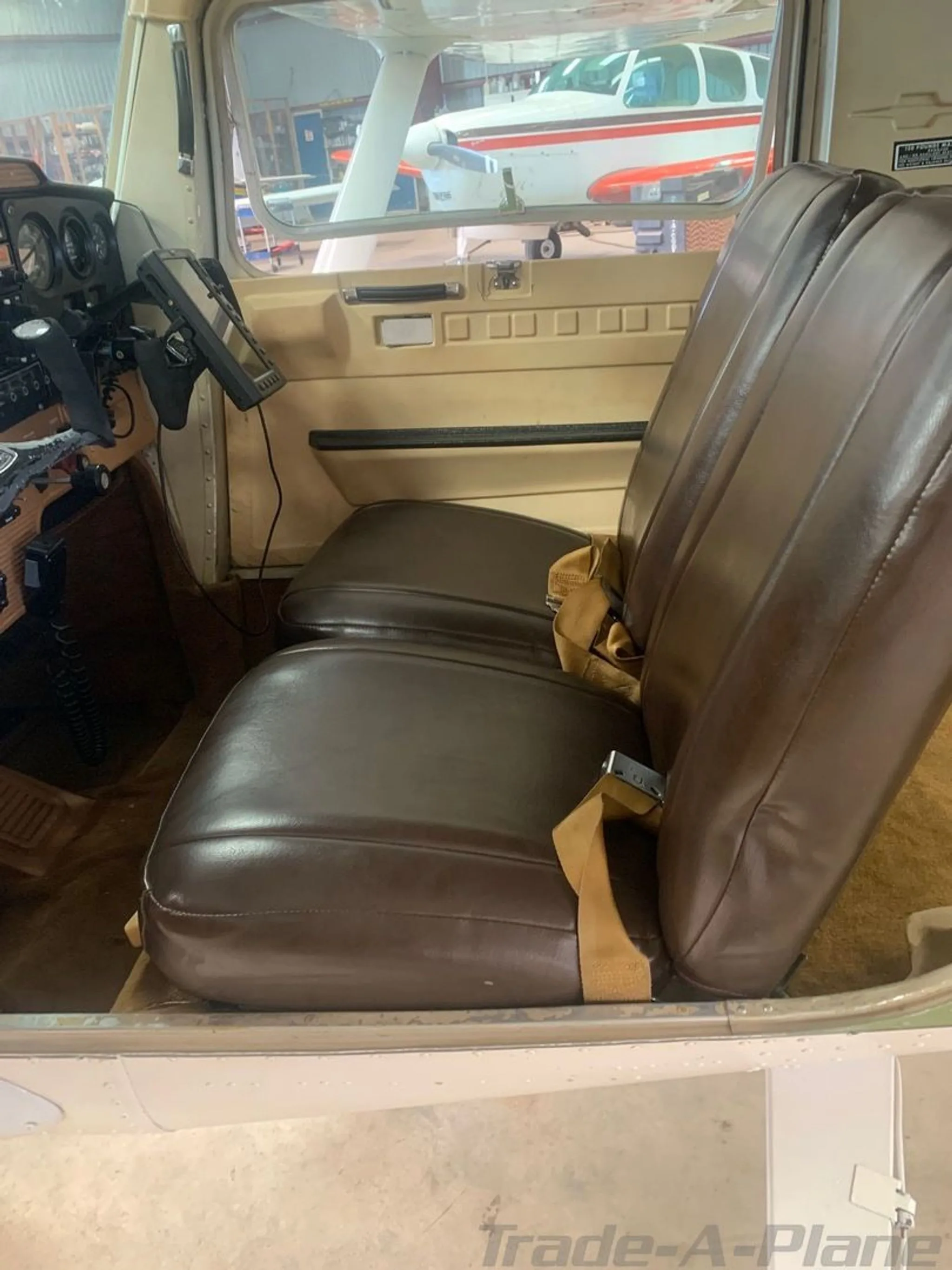 The brown leather seats and a partial view of the cockpit in the aircraft's cabin.