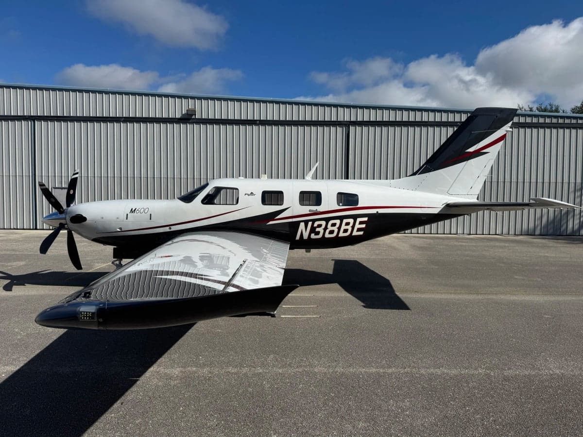 Side view of a Piper M600 aircraft with a white and black paint scheme on the tarmac.