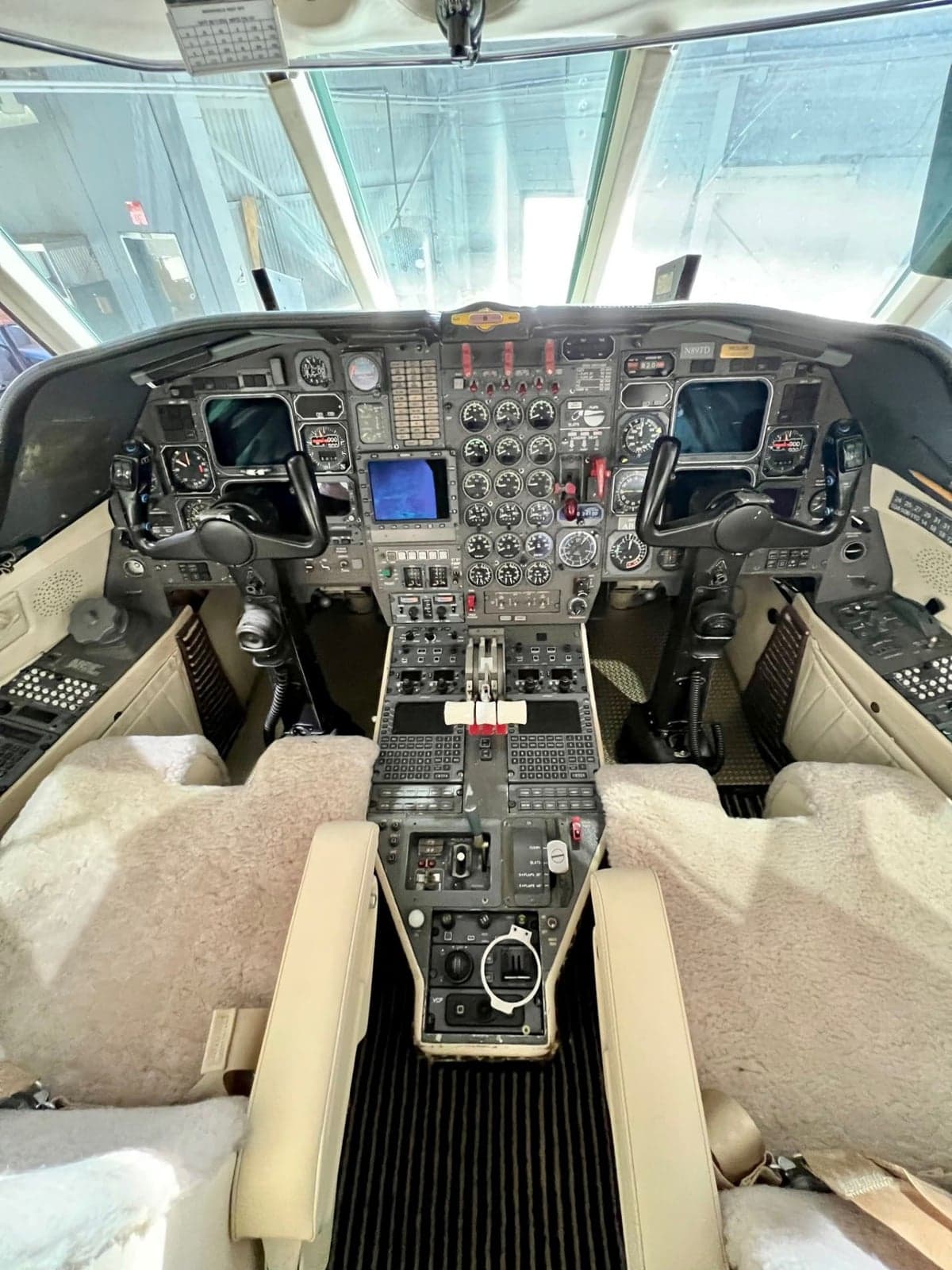 The cockpit of a Dassault Falcon 900 features dual flight controls and a full instrument panel.