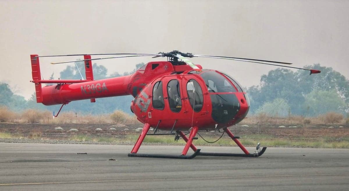 A red MD 500 helicopter, registration N39GA, sitting on the tarmac.