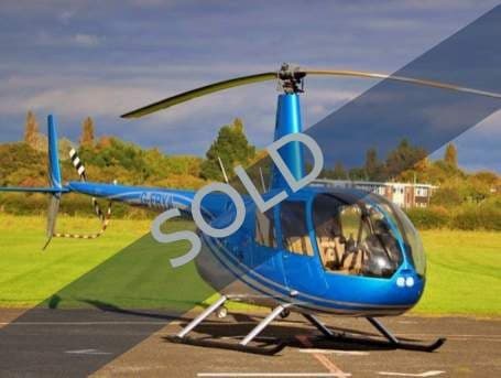 A blue Robinson R44 helicopter on the ground with a SOLD overlay.