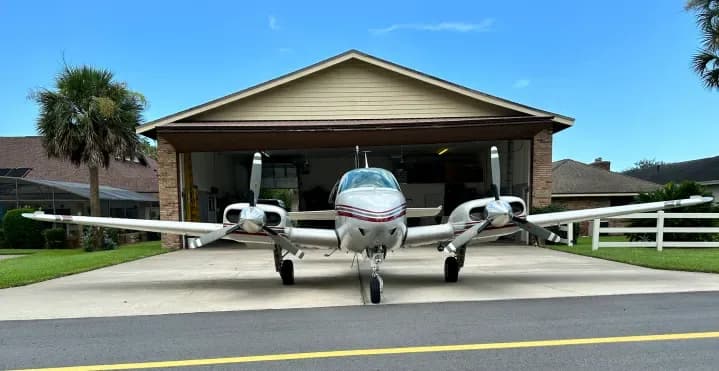 Front view of the Beechcraft Baron N41TG parked in front of a hangar.