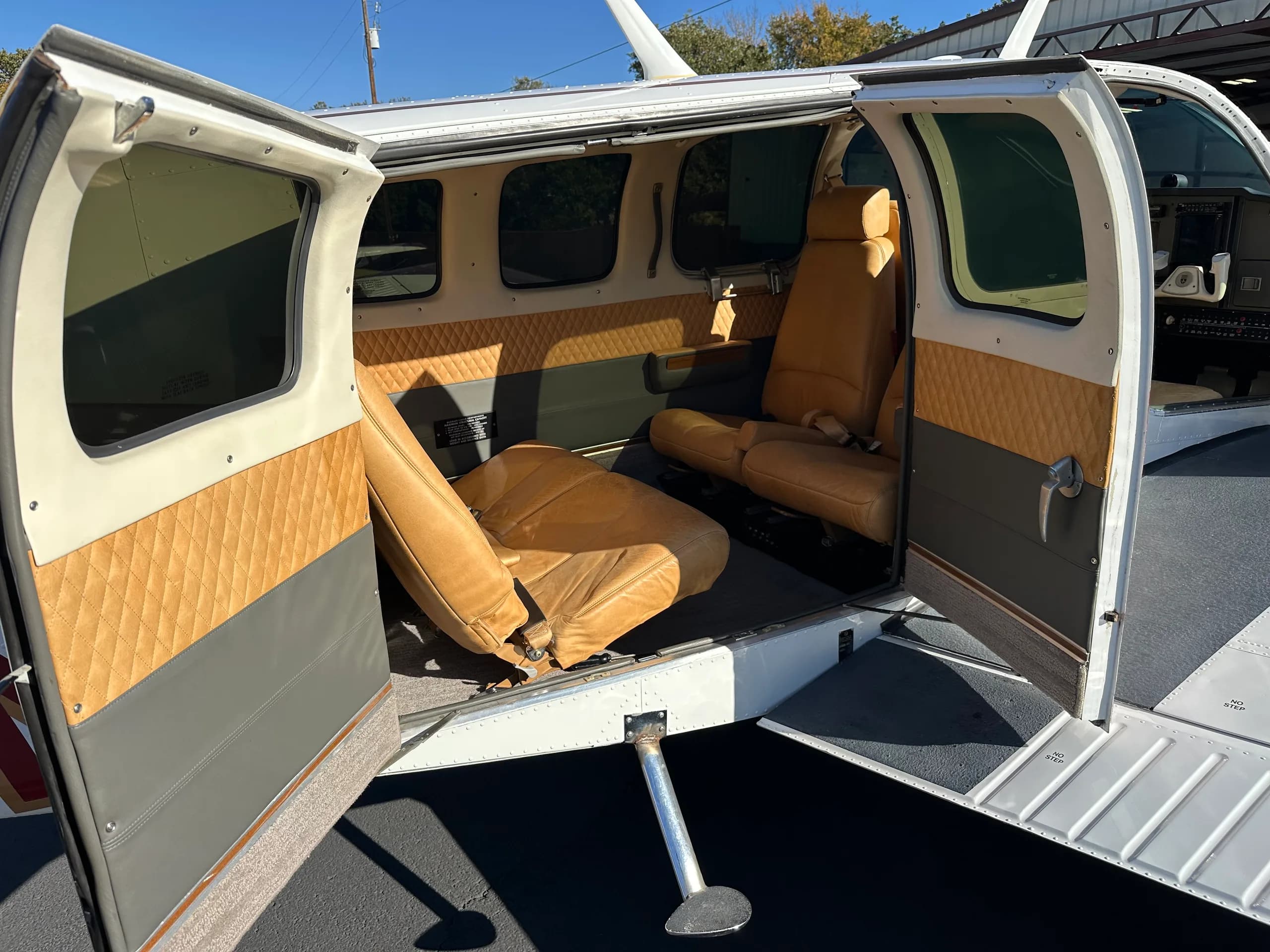 The interior of the aircraft is visible through the open doors, showing the seats.
