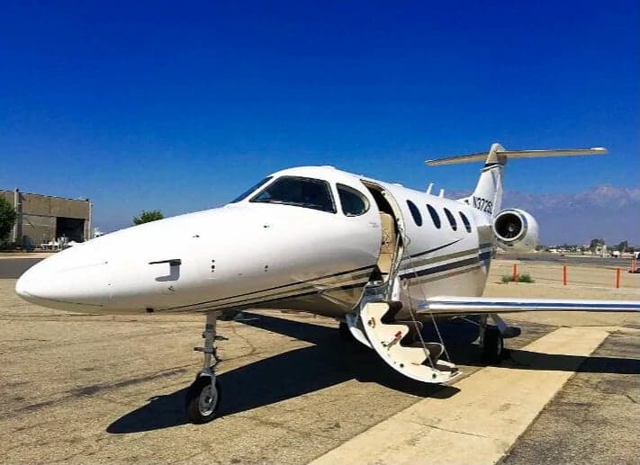 A white jet with registration N3728L parked on the tarmac with the airstair door open.